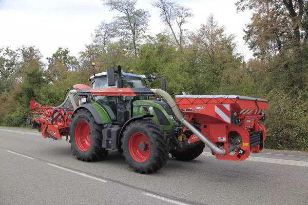 Machine-tractor unit equipped with a TF 1512 front hopper with load balance in transport mode.