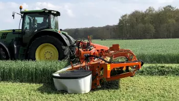 The mower conditioner with conveyor at work in a field in Germany